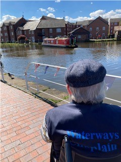 A waterways chaplain contemplating by a canal.